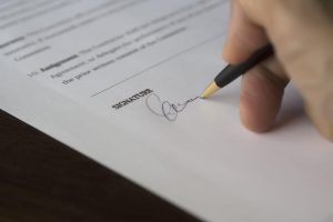 Selective focus on a person signing a document